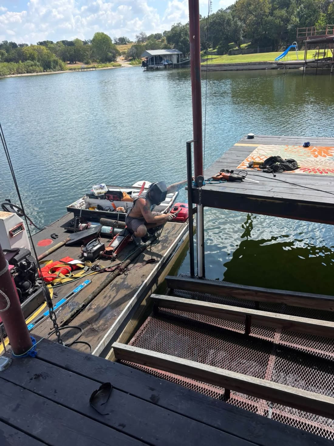 Welding steel framing on the water from a work barge alongside a dock on Lake Granbury